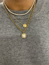 Load image into Gallery viewer, Willow Roe 14K Gold layered necklaces, featuring a diamond tennis necklace, a pleated, sunburst center diamond pendant, and a thicker chain links with pearl pendant on a model's neck