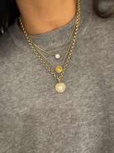 Load image into Gallery viewer, Willow Roe 14K Gold layered necklaces featuring a diamond solitaire pendant, the Sienna pleated sunburst pendant with center diamond, and a thick chain links necklace with peal charm on model's neck wearing g gray sweater 
