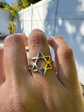 Load image into Gallery viewer, Willow Roe 14K solid gold Star of David ring featured on a hand in front of a white fence. 
